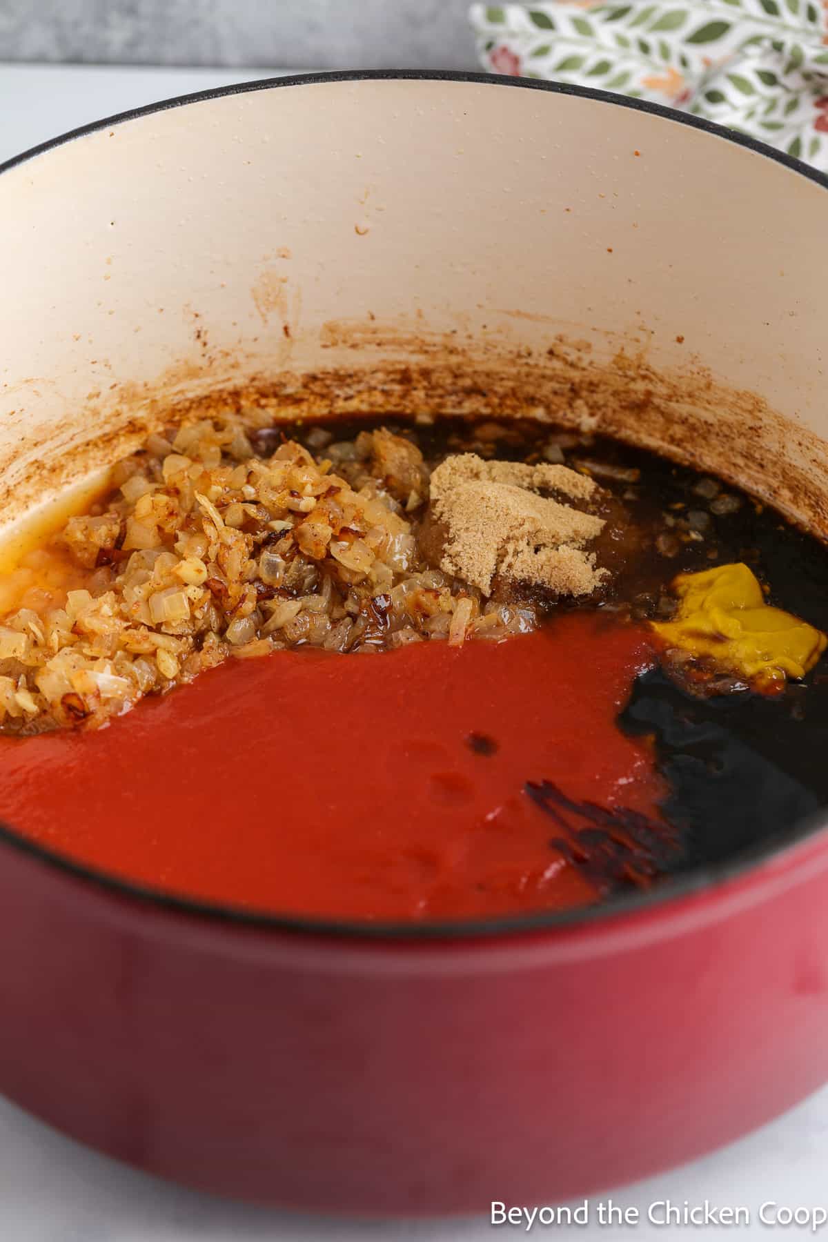 Adding tomato sauce to a large pot along with seasoning.  