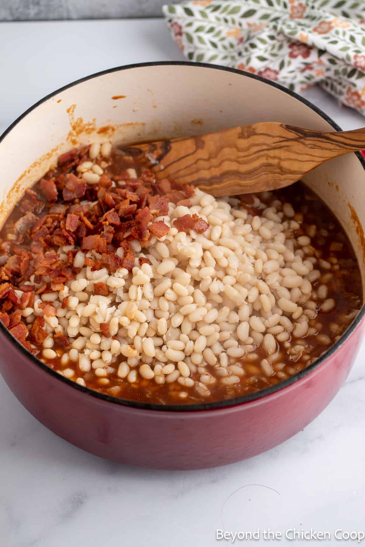 White beans in a pot with bacon. 