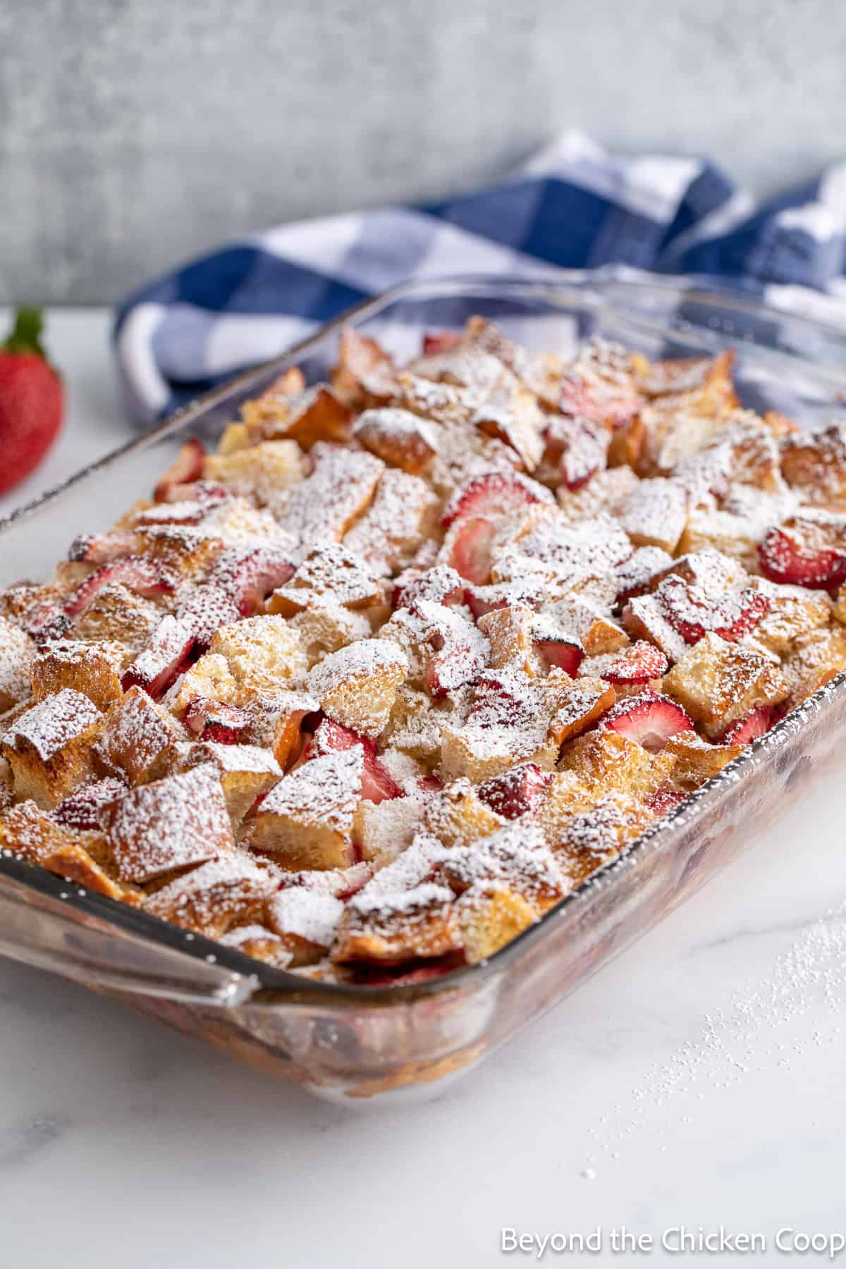 A baked breakfast casserole topped with powdered sugar. 