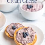 Bagels topped with cream cheese and fresh blueberries.