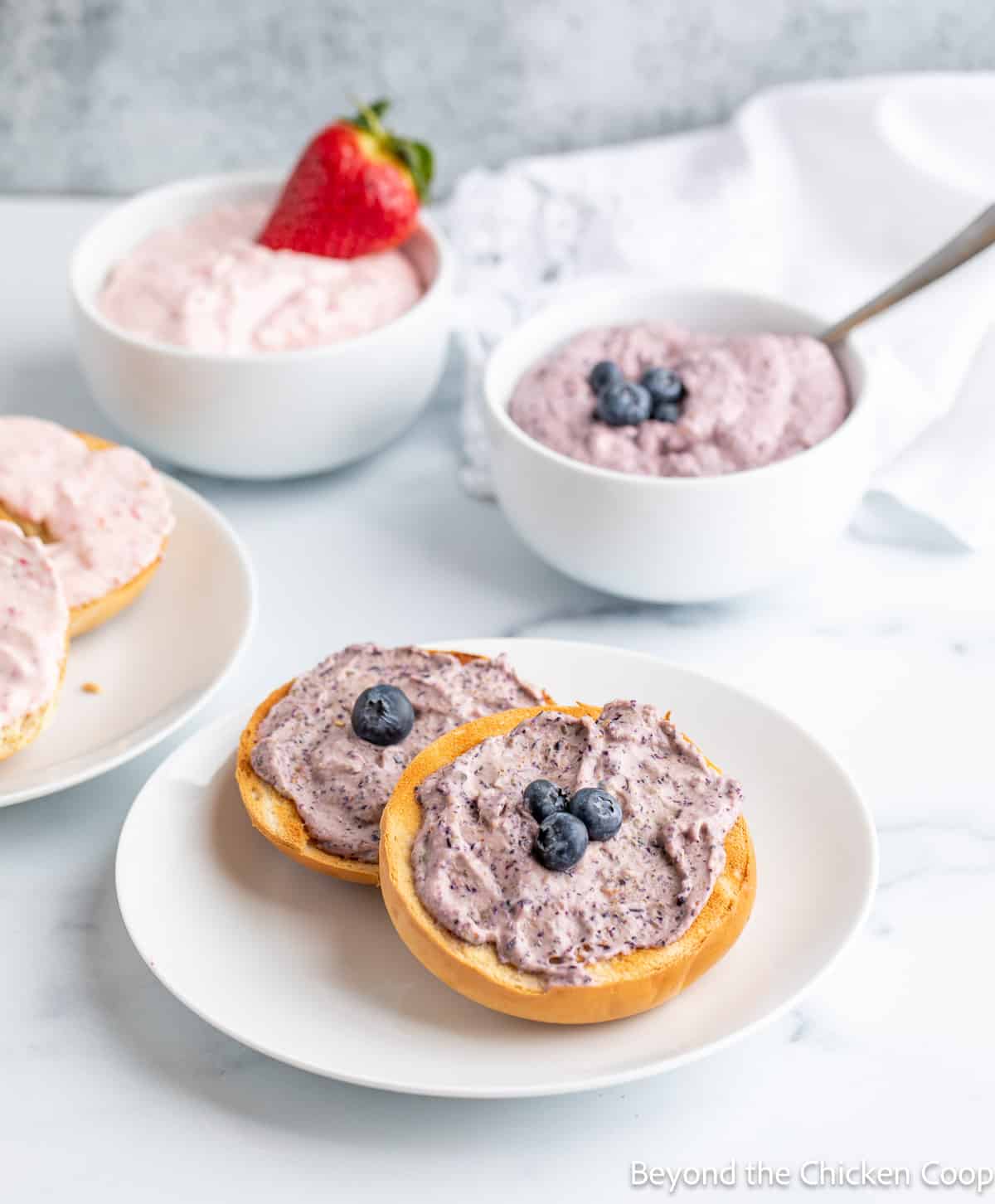 Bagels topped with a fruit cream cheese spread. 