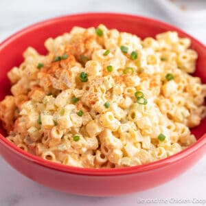 Pasta salad topped with green onions and paprika.