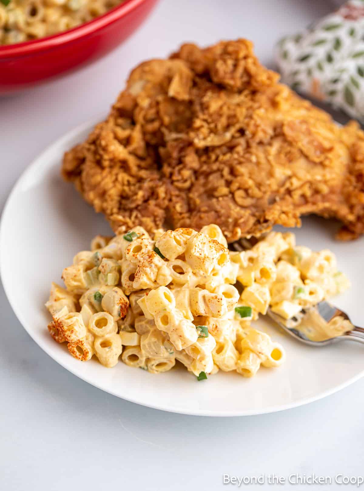 A plate with fried chicken and a pasta salad. 
