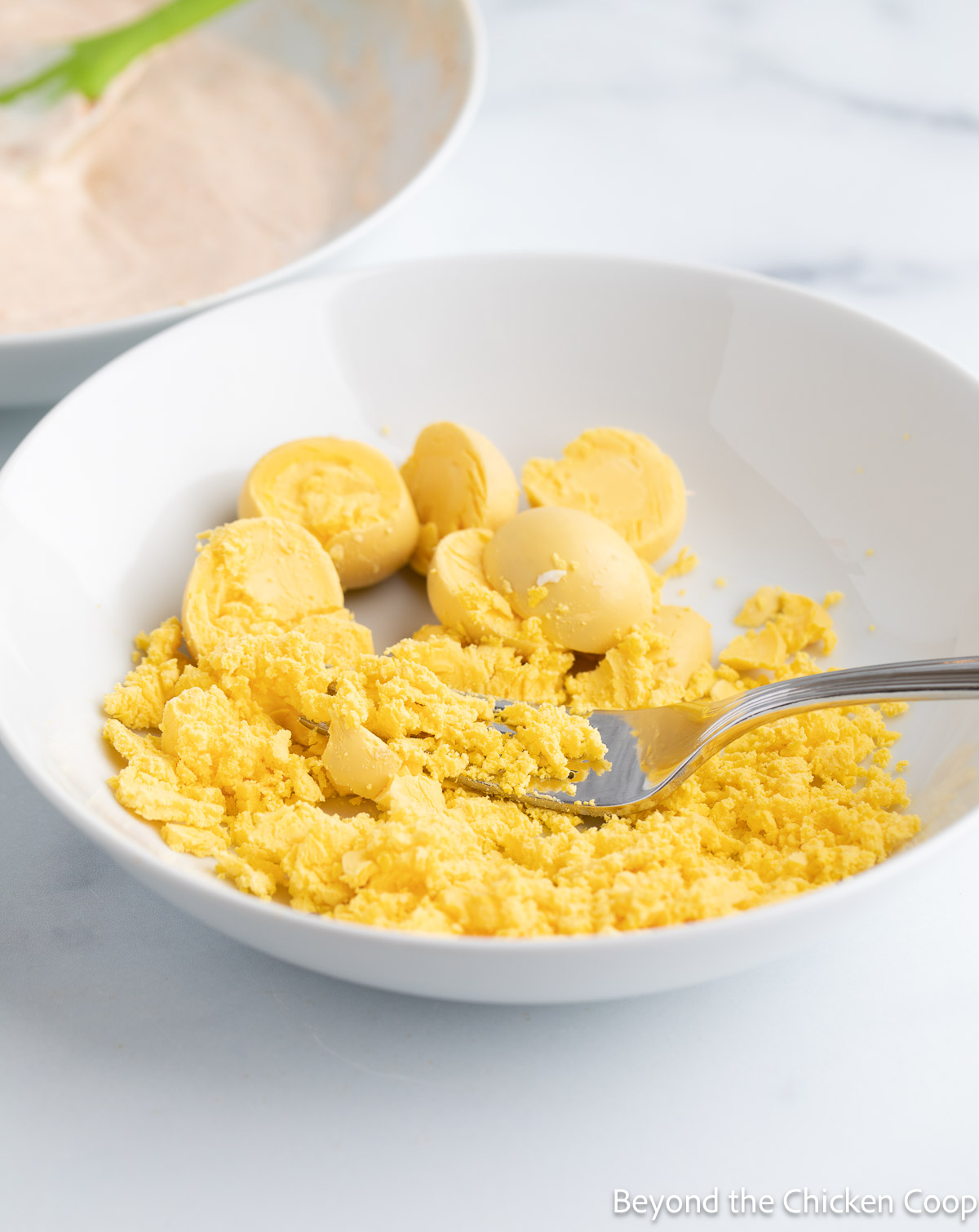 Mashing egg yolks with a fork. 