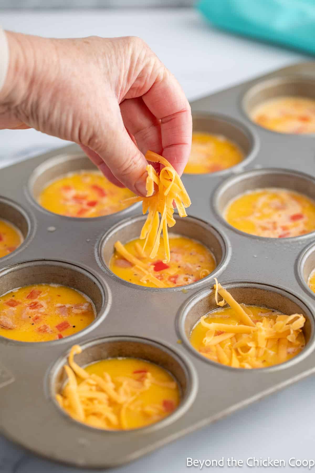 Sprinkling cheese over egg mixture. 