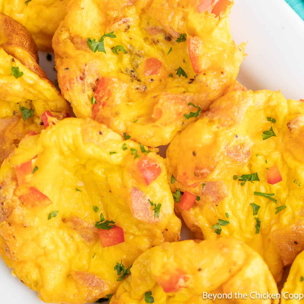 Baked mini frittata eggs on a white tray. 