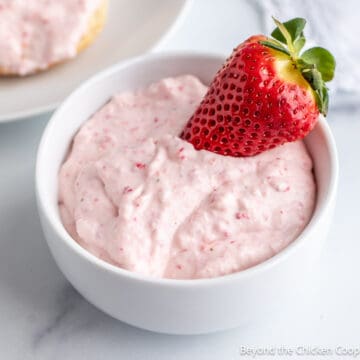 A bowl filled with strawberry cream cheese.