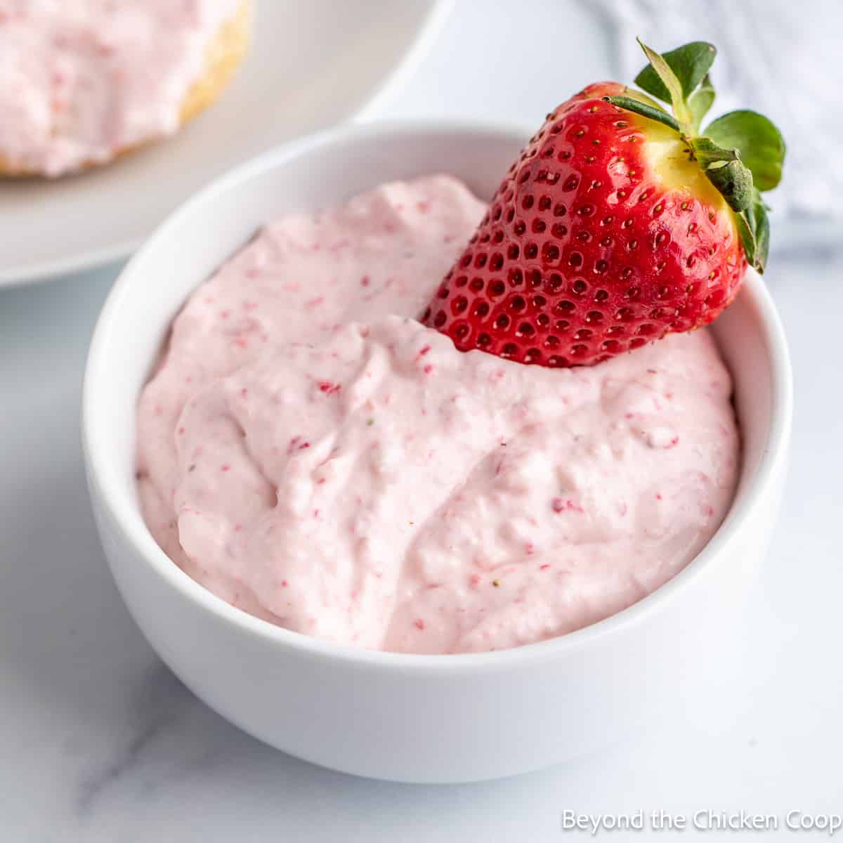 A bowl filled with strawberry cream cheese.