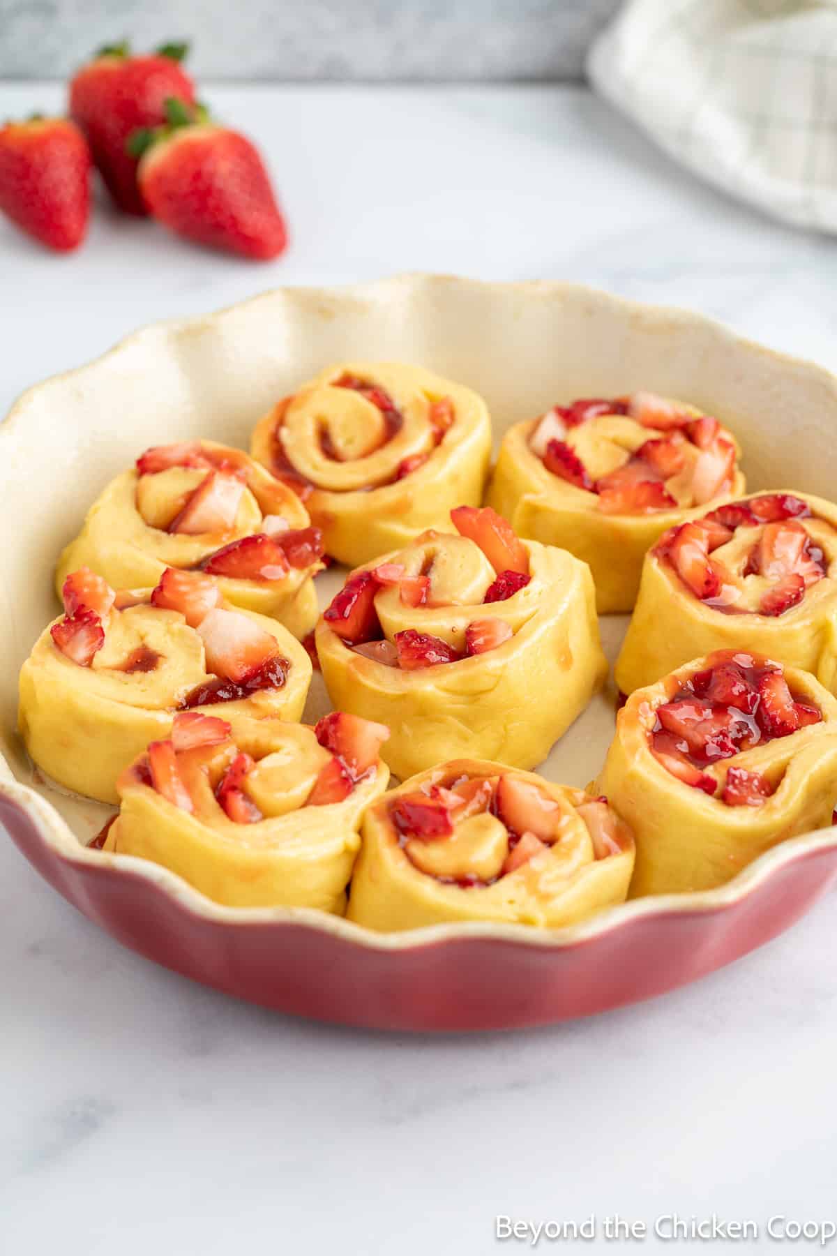 Unbaked cinnamon rolls filled with strawberries. 