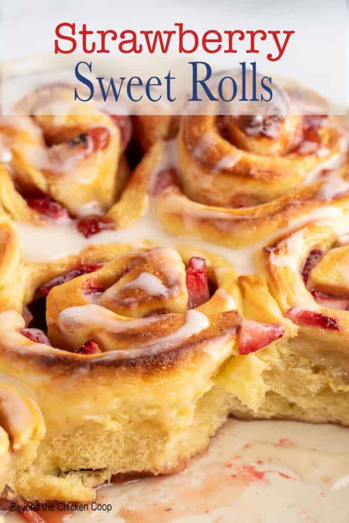 Cinnamon rolls filled with strawberries in a baking dish.