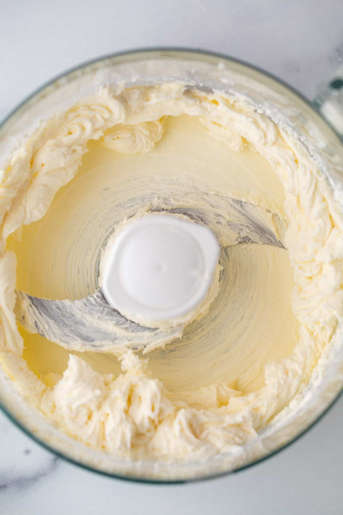 Blended cream cheese in a food processor bowl. 