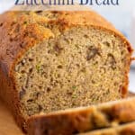 Zucchini bread with nuts sliced on a cutting board.