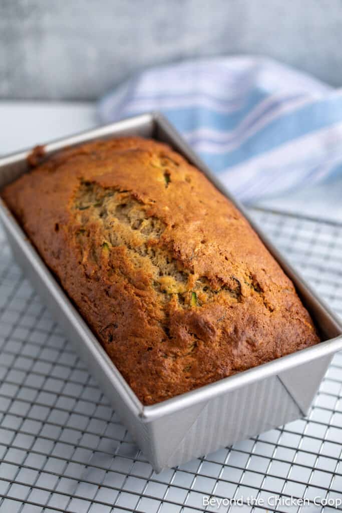 A loaf of baked bread in a loaf pan. 