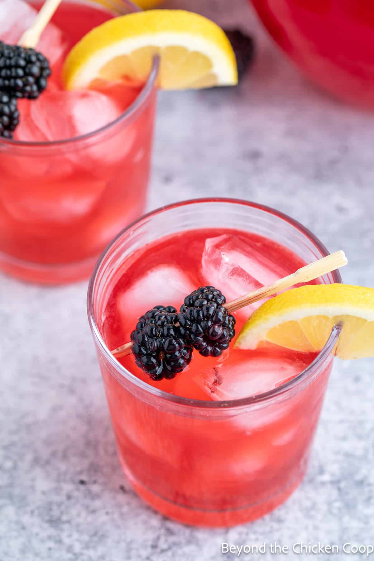 Pink lemonade topped with fresh blackberries and a lemon slice.