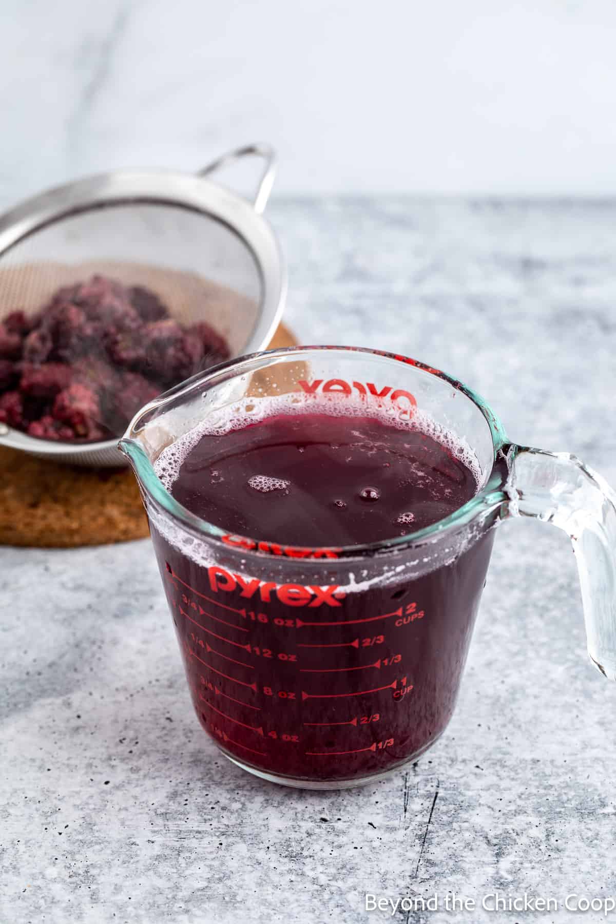 Strained blackberry juice in a measuring cup. 