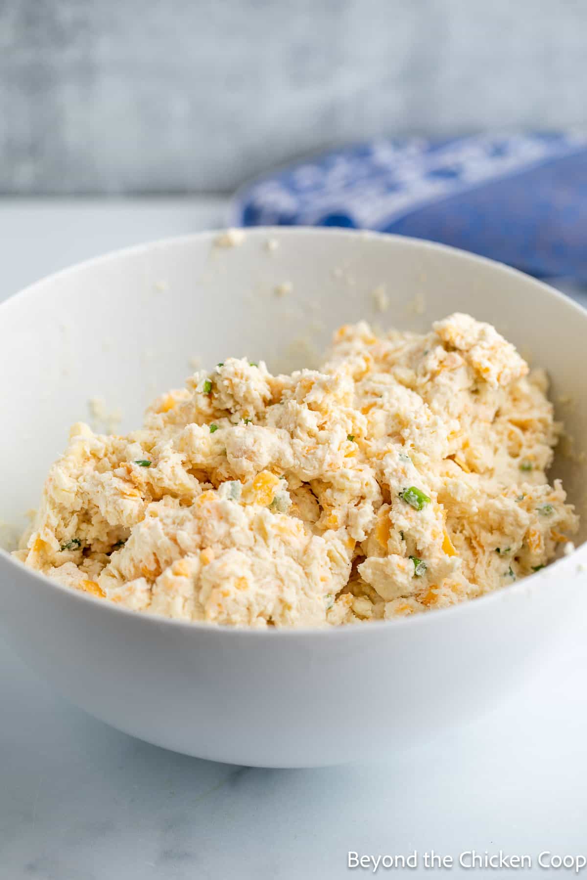 A bowl filled with biscuit dough. 