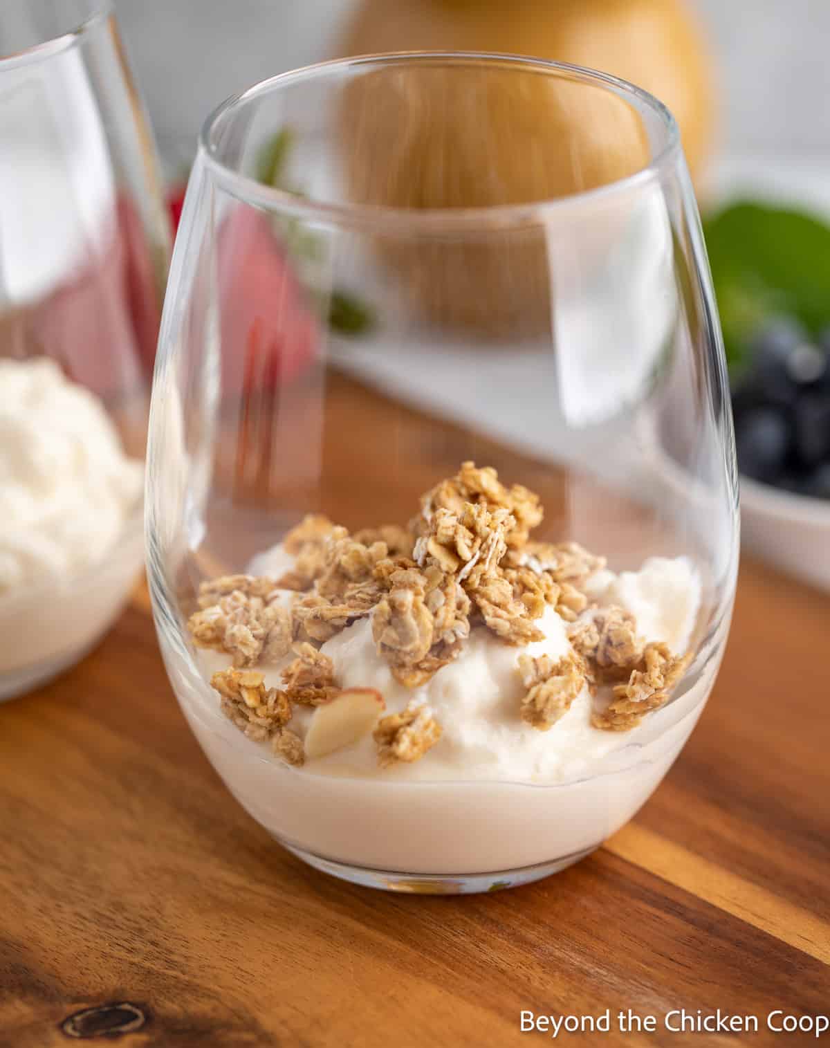 A layer of yogurt topped with granola in a glass.