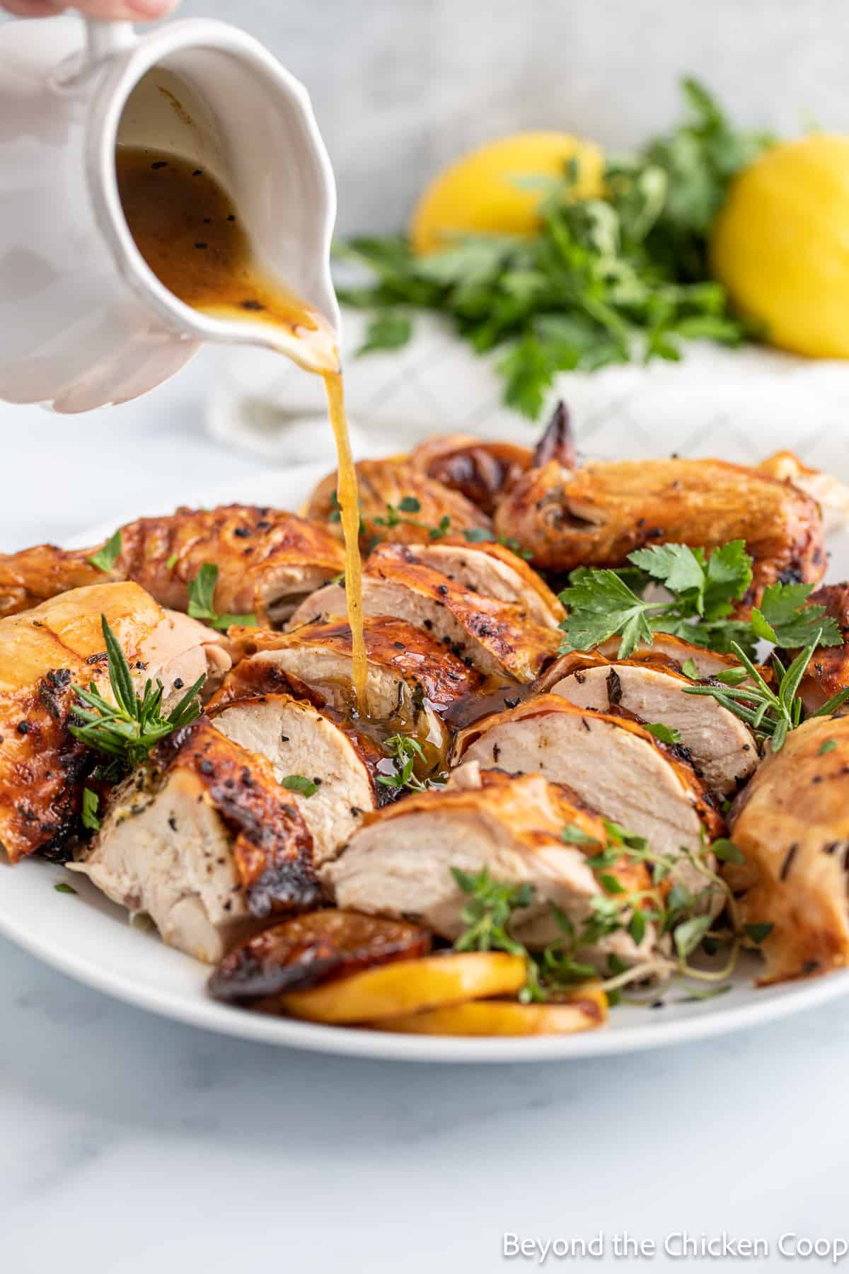 Pouring a butter sauce over roasted chicken. 