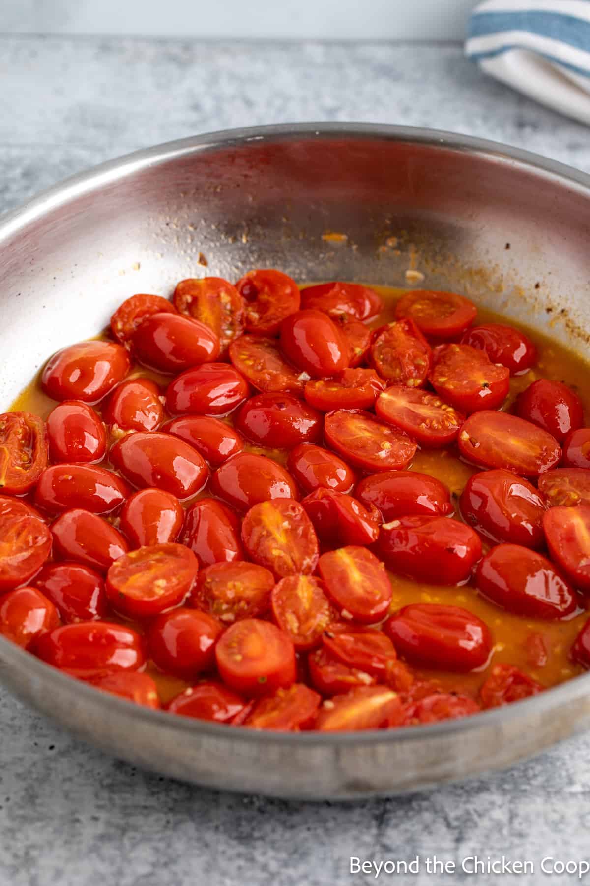Cooked cherry tomatoes in a pan. 
