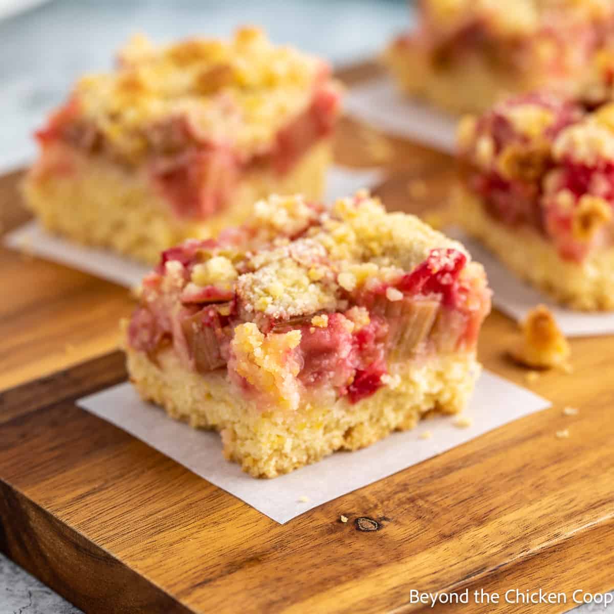 Squares of a rhubarb dessert on a wooden board. 