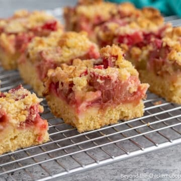 Squares of rhubarb bars on a baking rack.