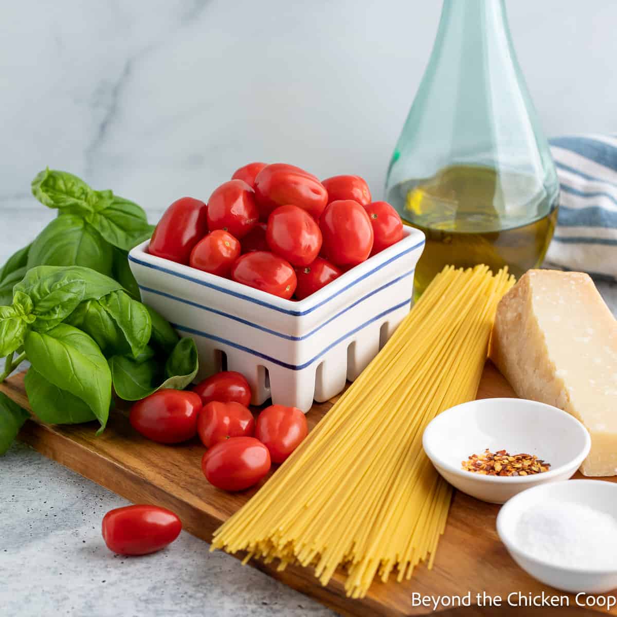 Ingredients for making a pasta dish with tomatoes and basil. 