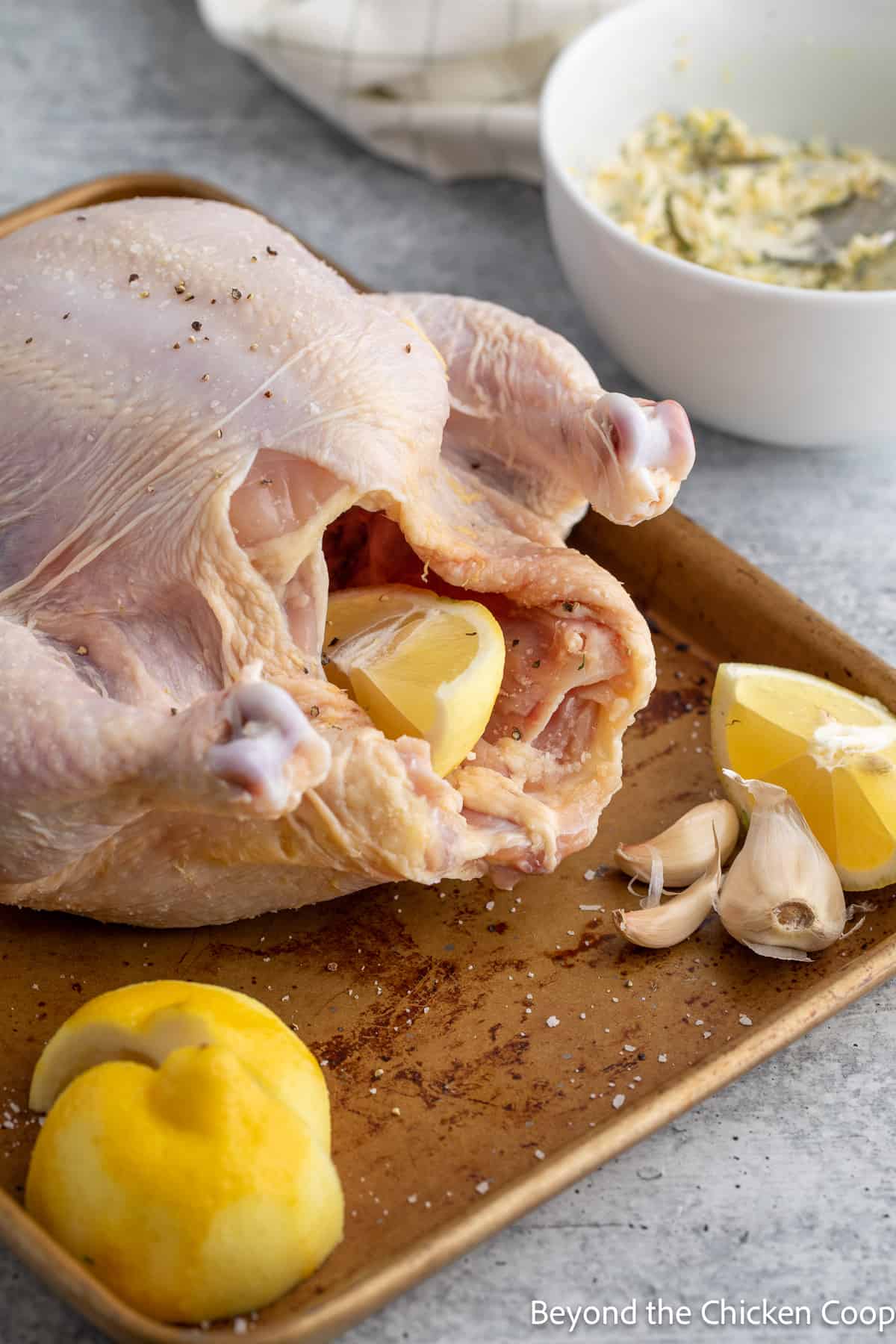 Placing lemons in the cavity of a chicken. 