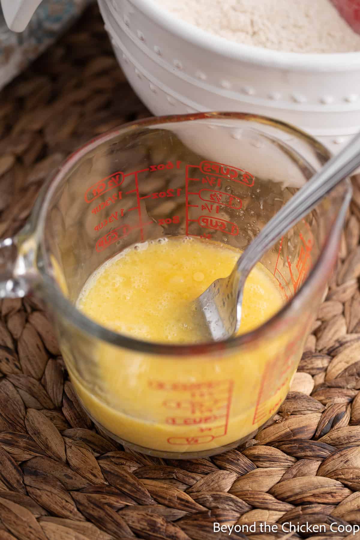 A glass measuring cup filled with eggs. 