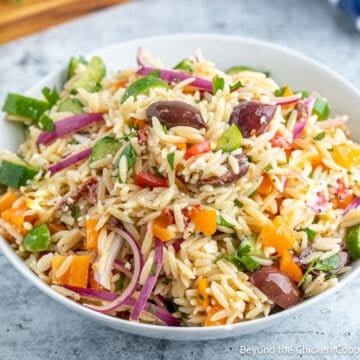 An orzo pasta salad with onions, olives and peppers.
