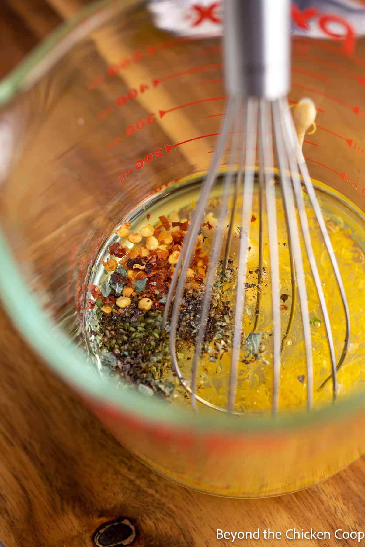 Mixing a homemade dressing in a glass measuring cup. 