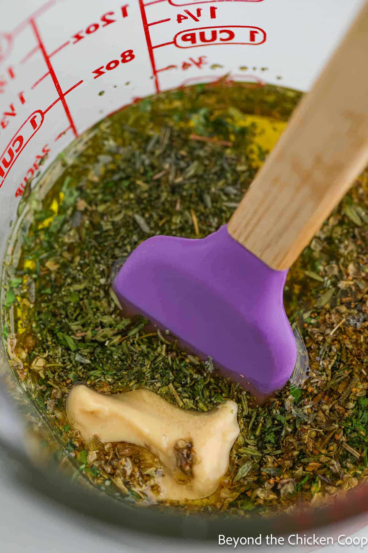 Oil and herbs in a large mixing bowl. 