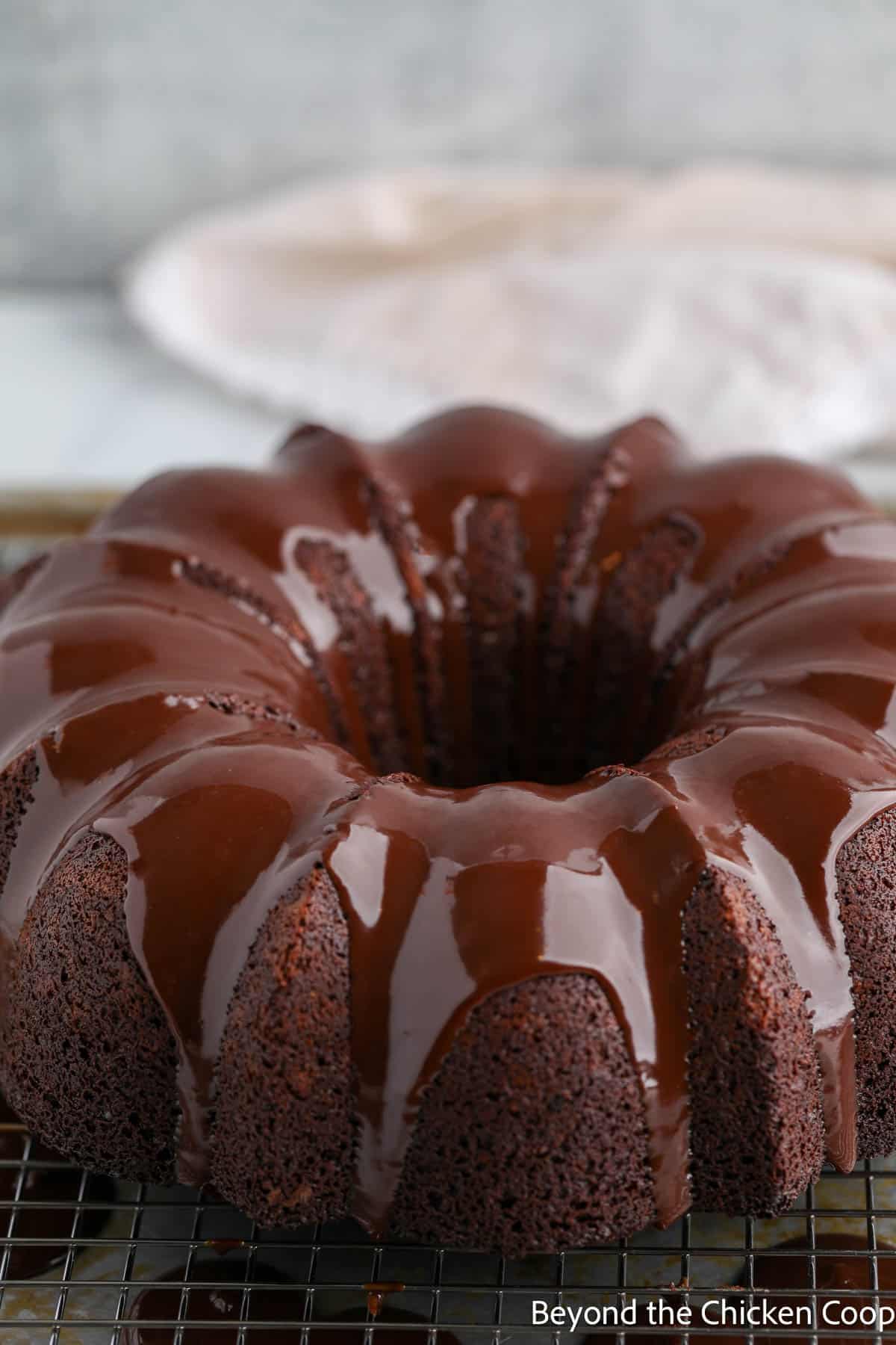 A glazed bundt cake on a baking sheet. 