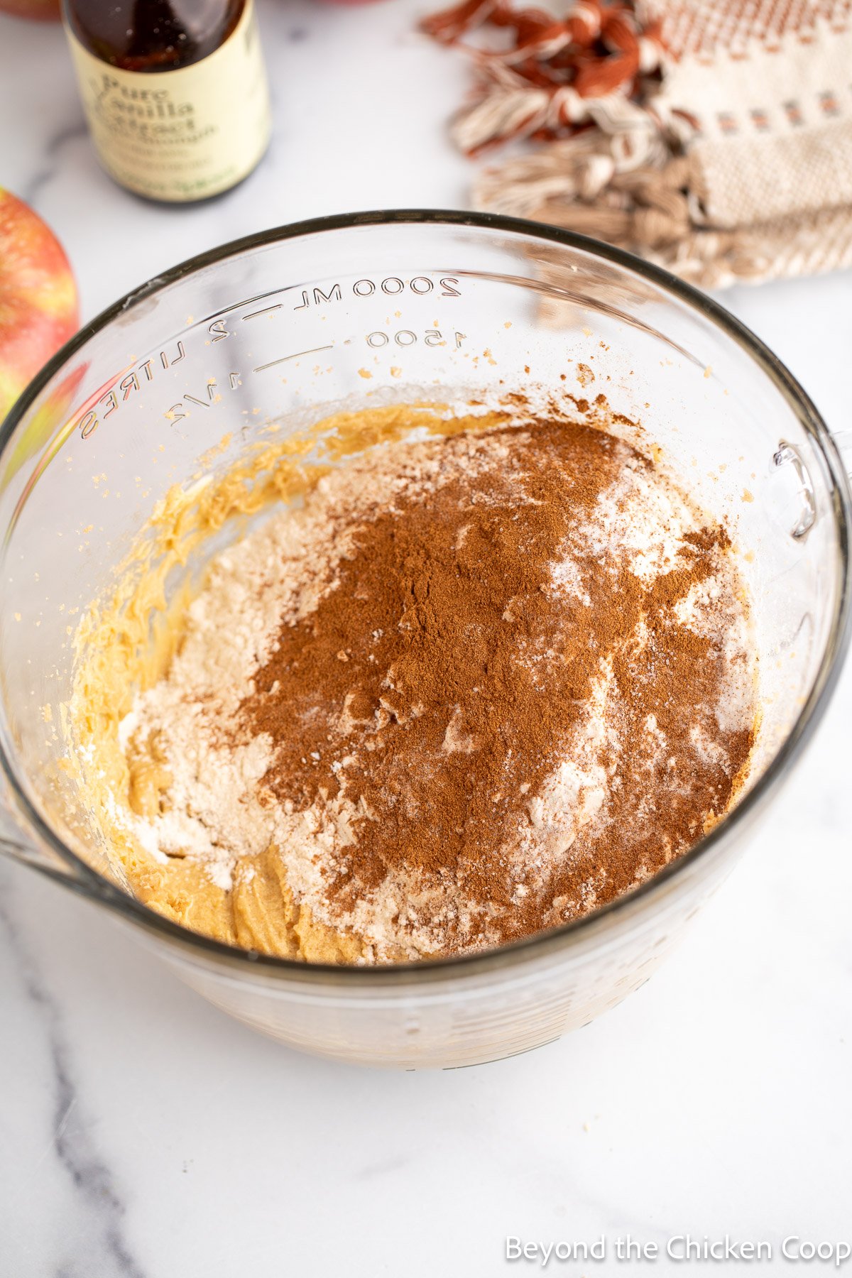 Flour and cinnamon in a bowl with cake batter. 