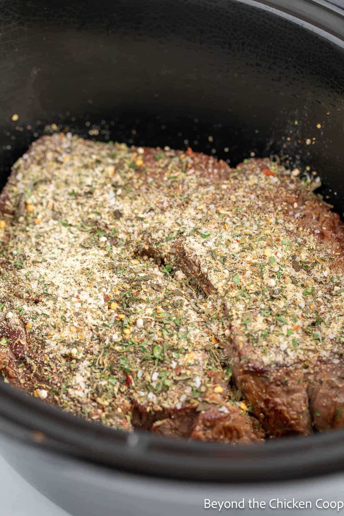 Seasoning a roast in the crockpot. 