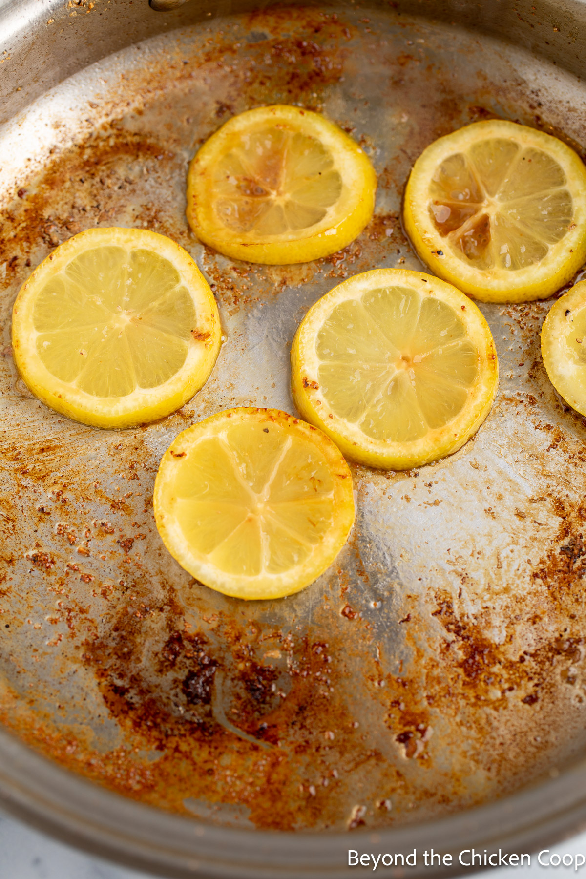 Browning lemon slices in a skillet. 