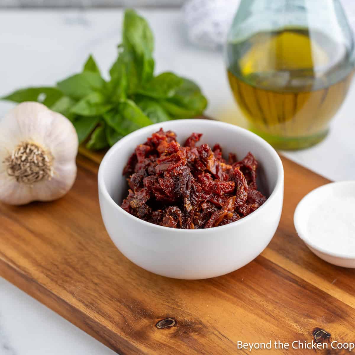 Sun dried tomatoes, basil and garlic on a wooden board. 