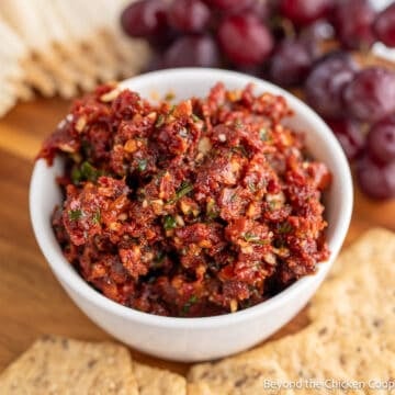 A white bowl filled with sun dried tomato spread.