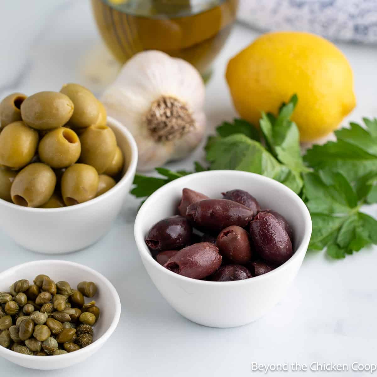 Small bowls filled with olives and capers. 