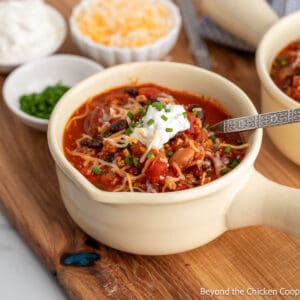 A bowl of chili topped with sour cream and cheese.