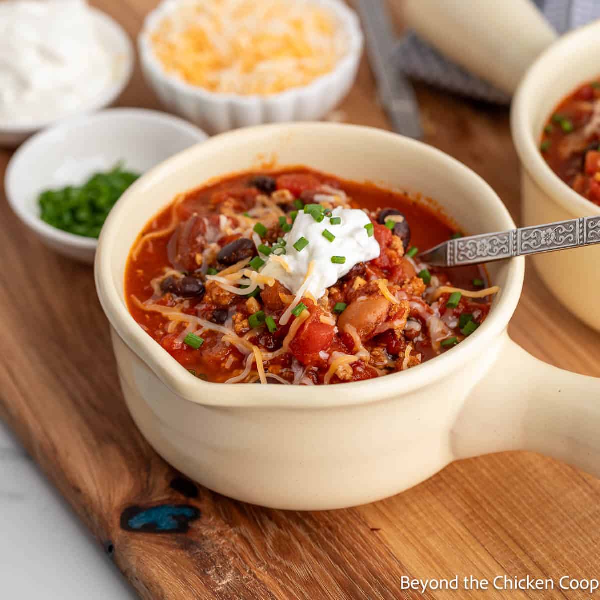 A bowl of chili topped with sour cream and cheese.