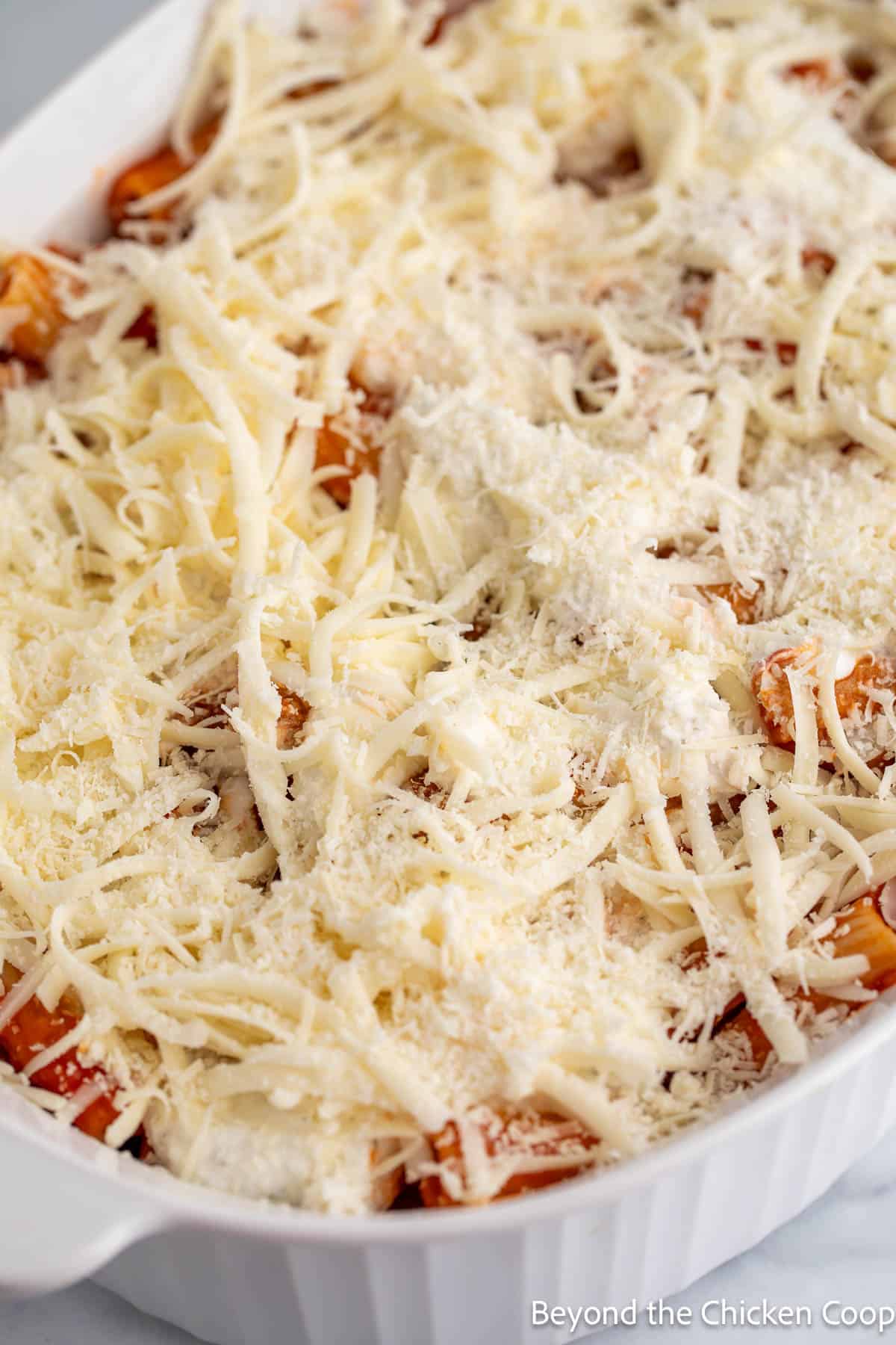 Shredded cheese on top of a pasta casserole. 