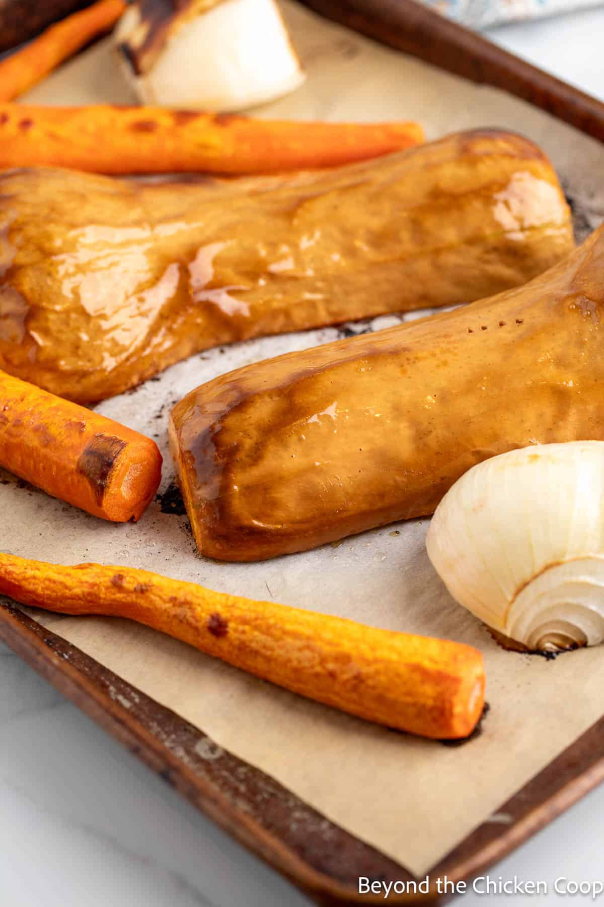 Roasted squash, carrots and onions on a baking sheet. 