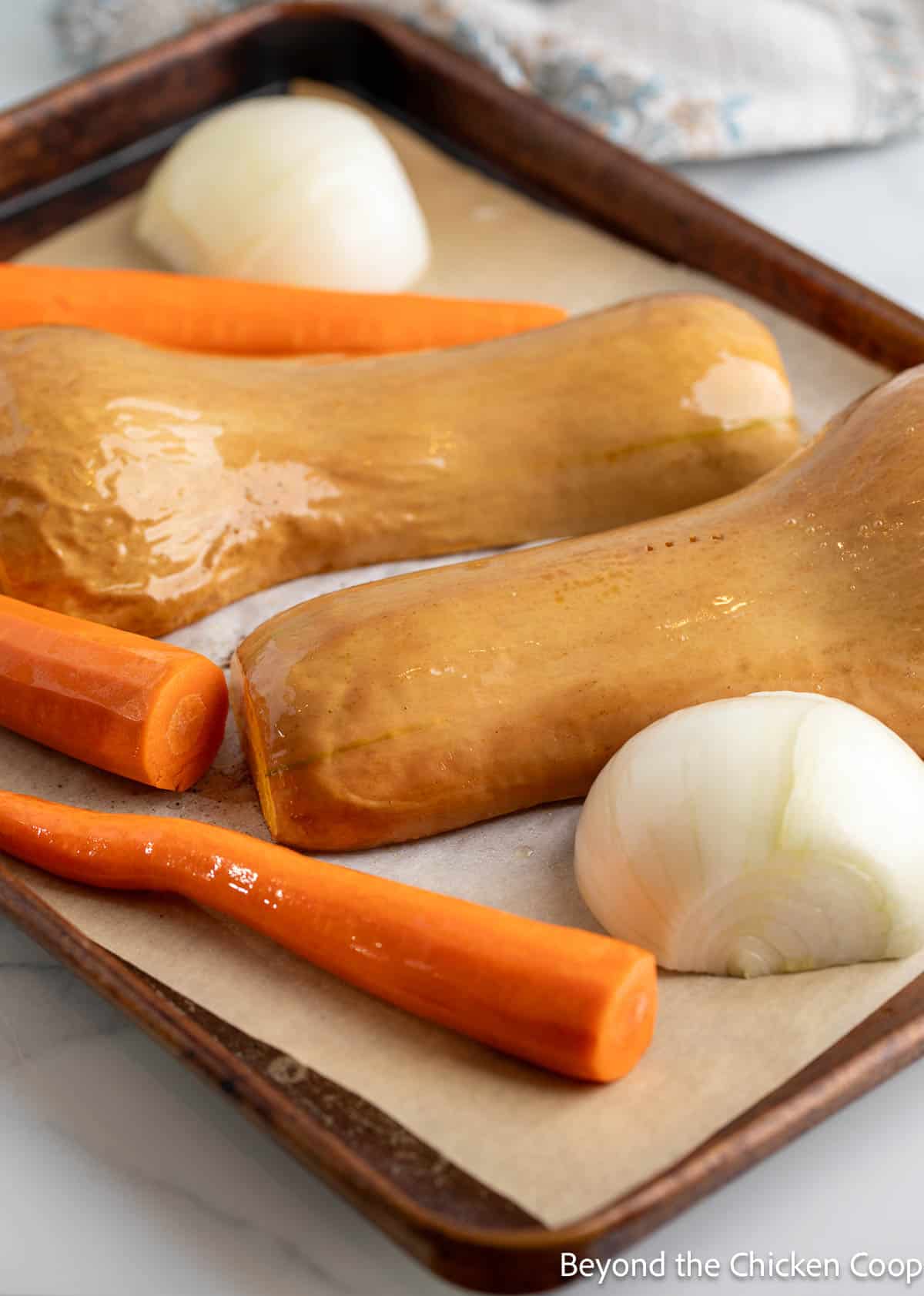 Squash, carrots and onions on a baking sheet. 