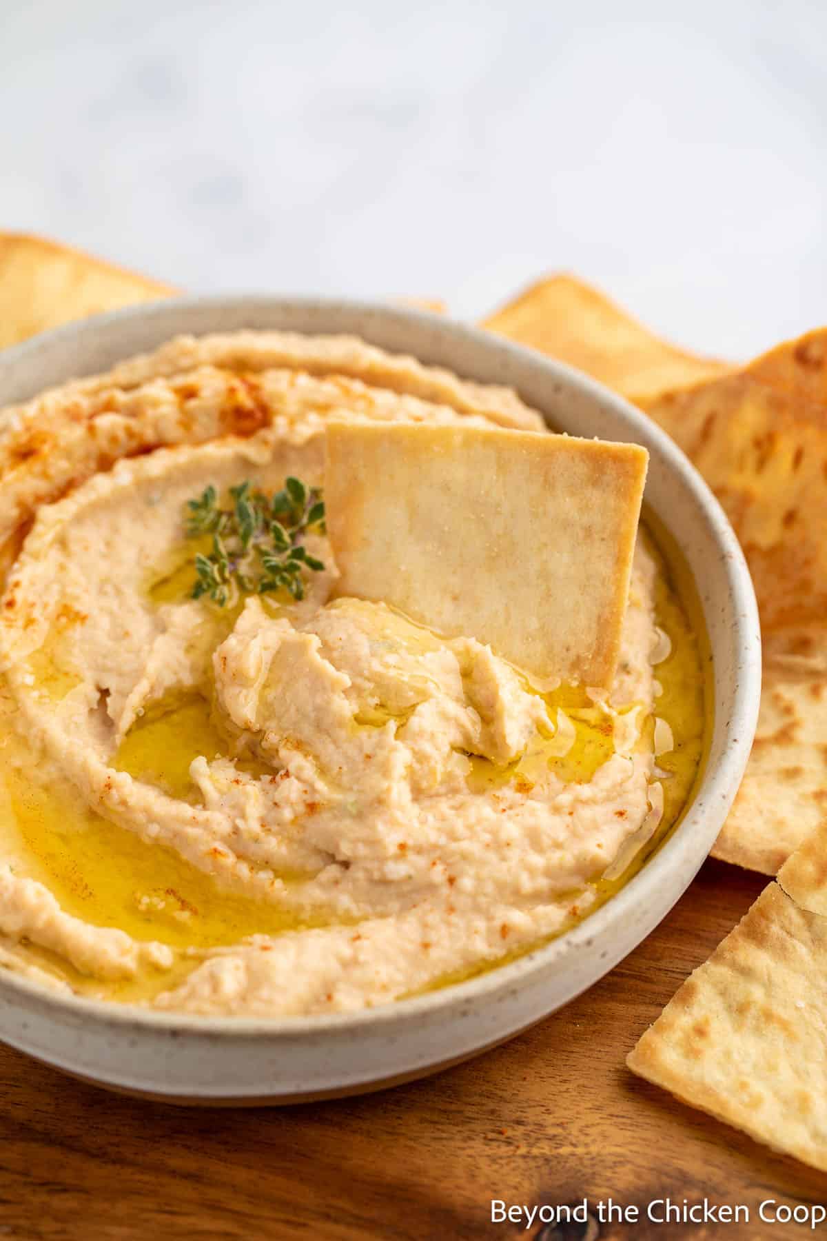 Bean dip with a pita chip in the dip. 