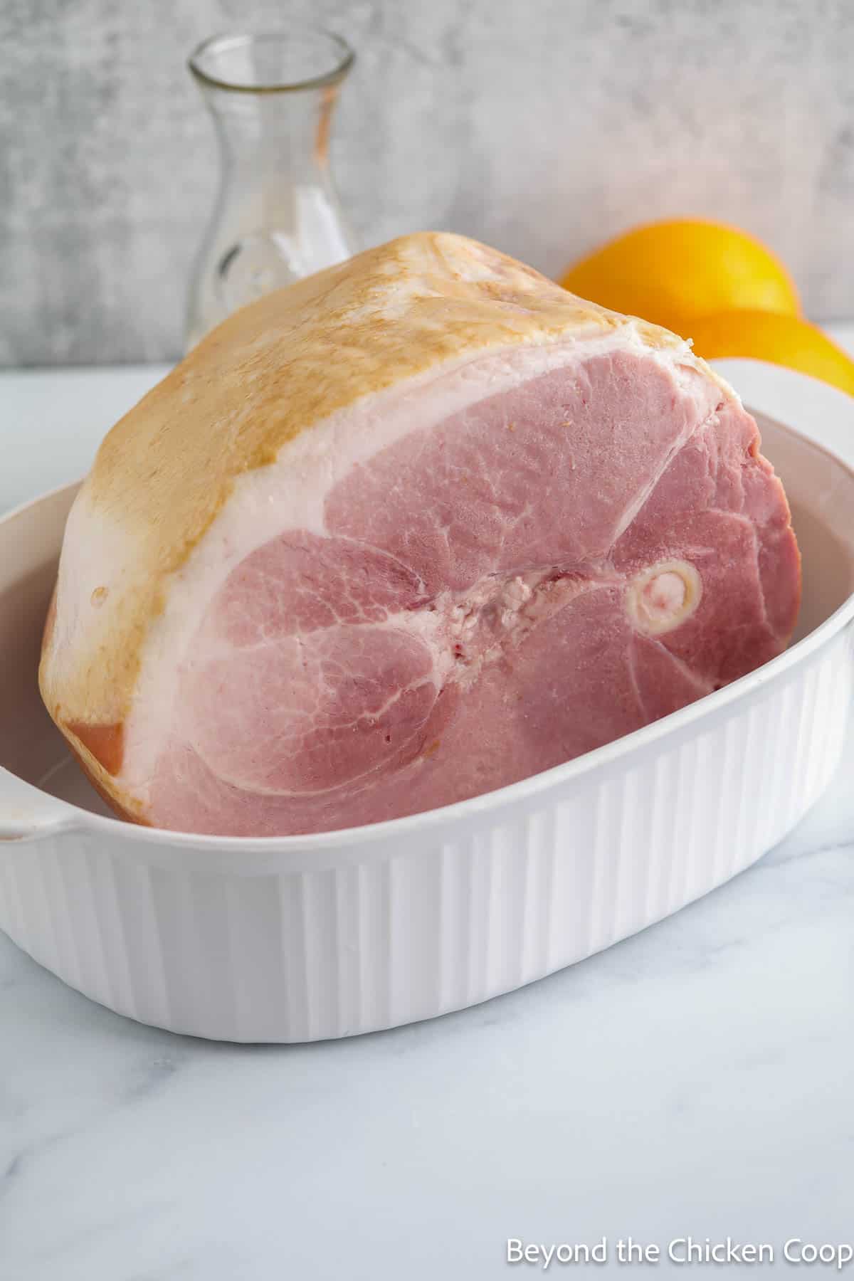 A bone-in ham in a baking dish. 