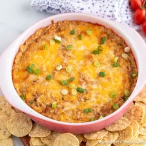 Cream Cheese Bean Dip in a casserole dish surrounded by chips.