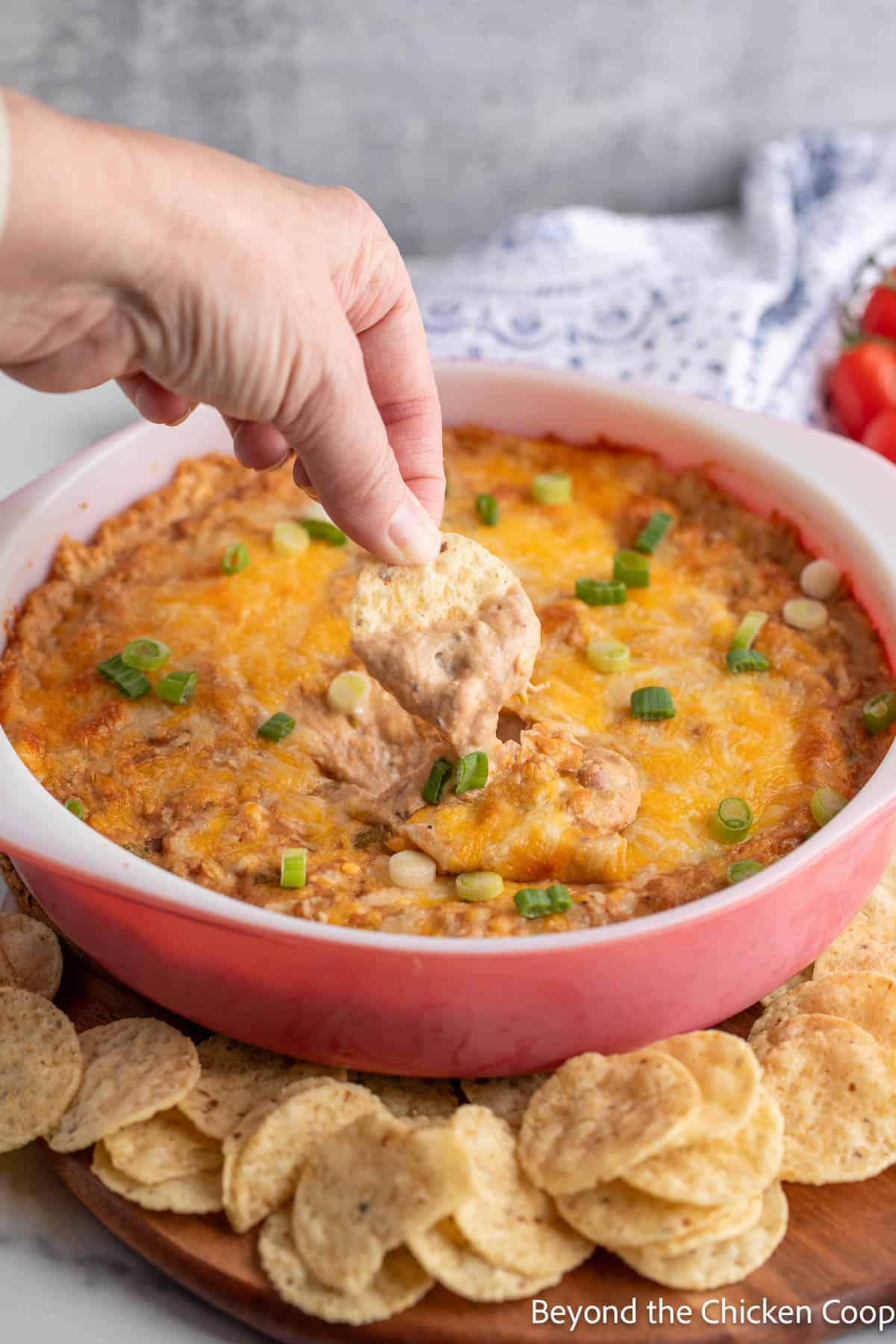 Scooping up refried bean dip with a tortilla chip. 