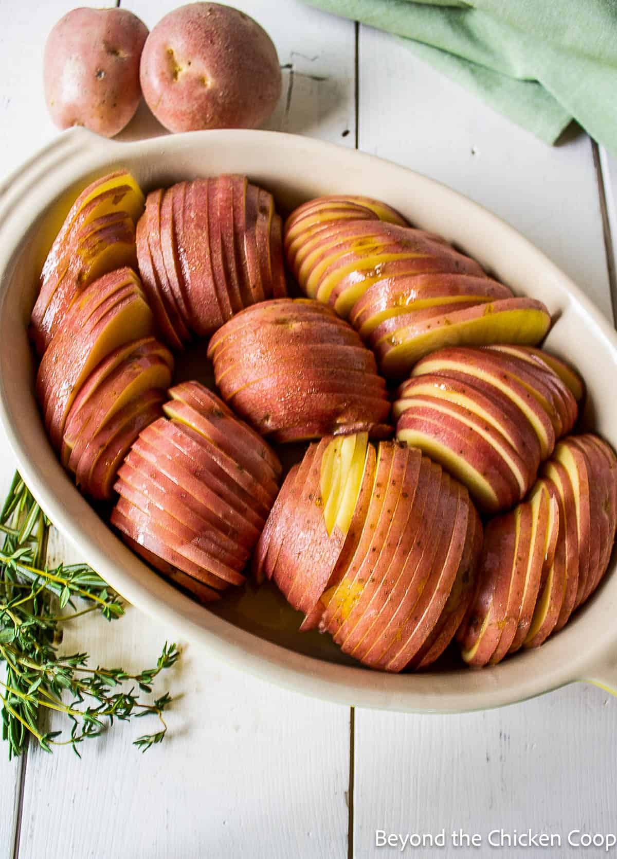 Thinly sliced red potatoes in a casserole dish.