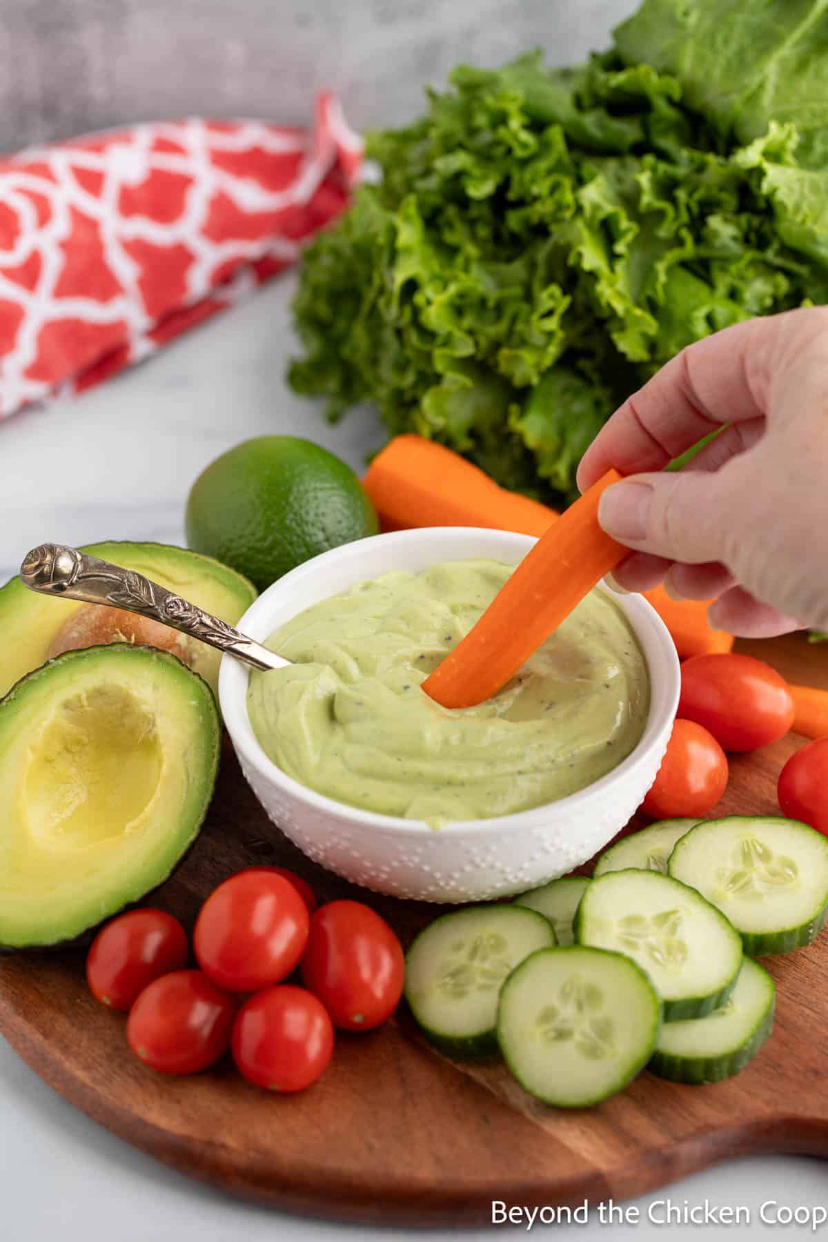 A carrot dipping into avocado ranch dressing. 