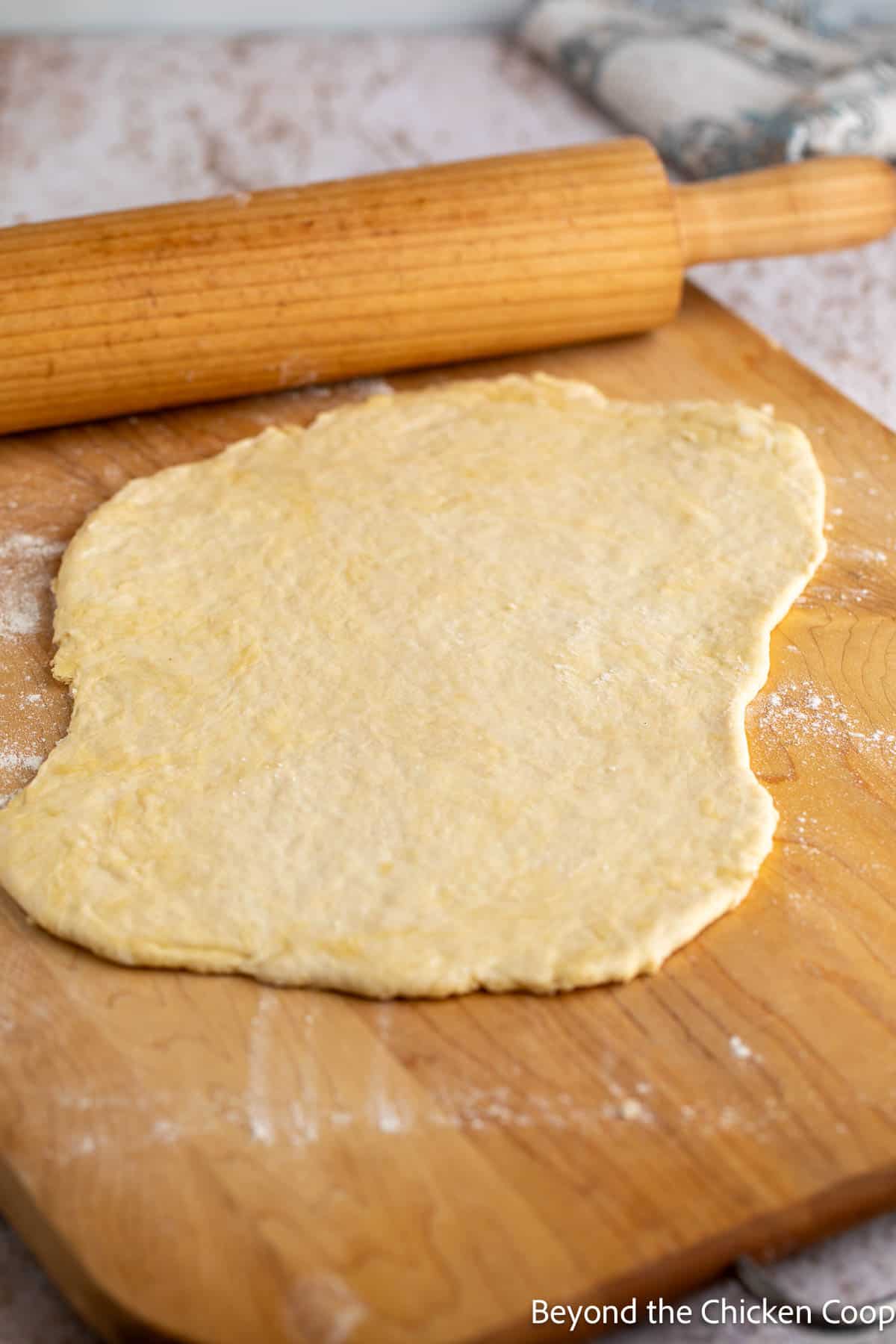Rolled out cracker dough on a wooden board. 